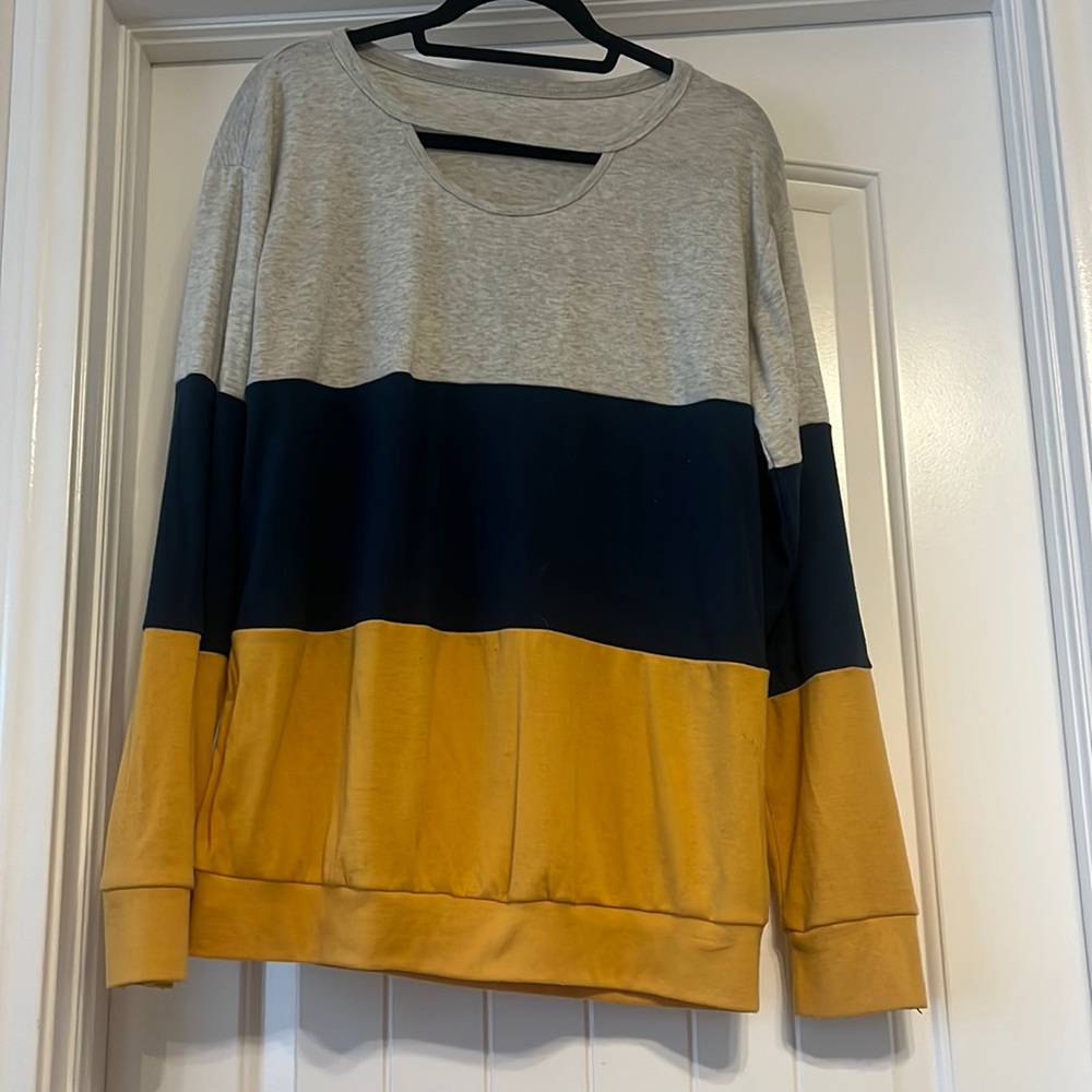 Light gray, navy blue, and yellow long sleeve with a peek-a-boo slit on top
